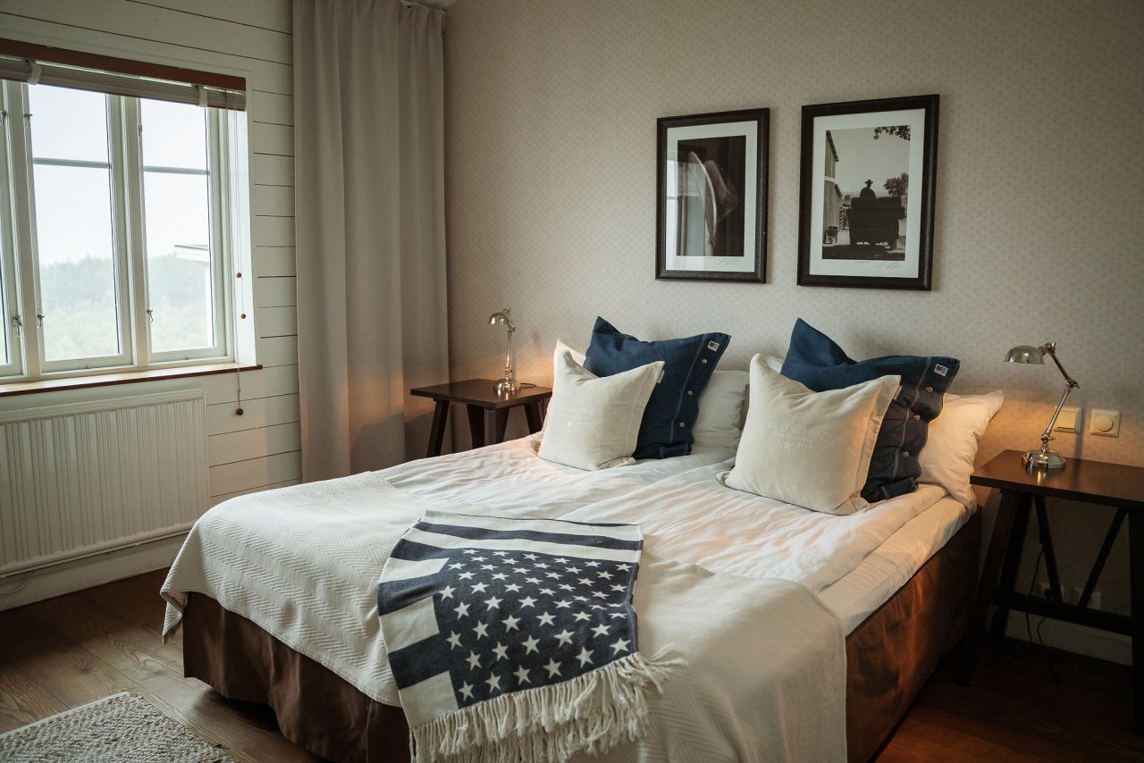 Hotellrum med dubbelsäng och blå kuddar på The Lodge