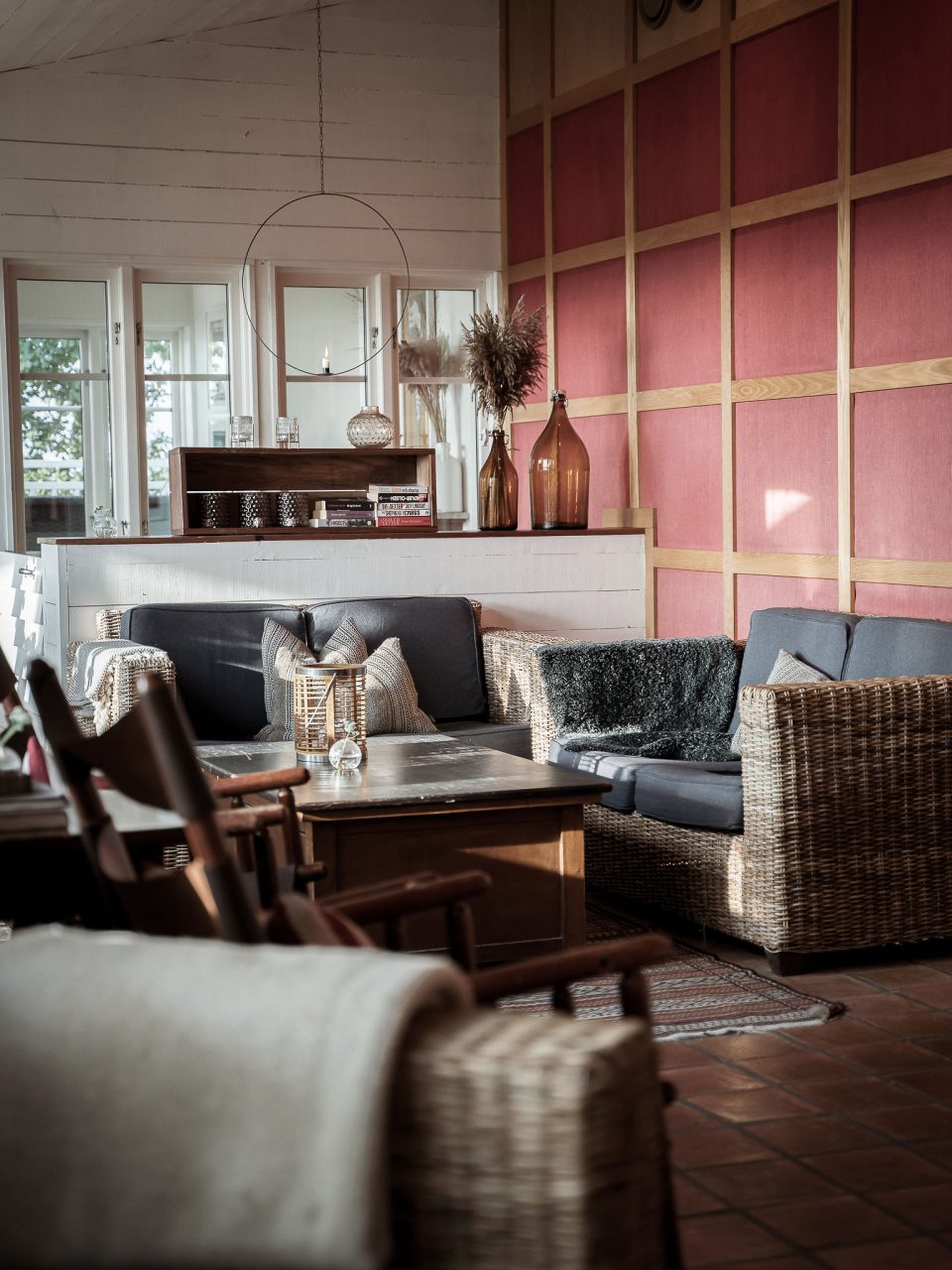 Loungehörna med soffor och röd panelvägg på The Lodge