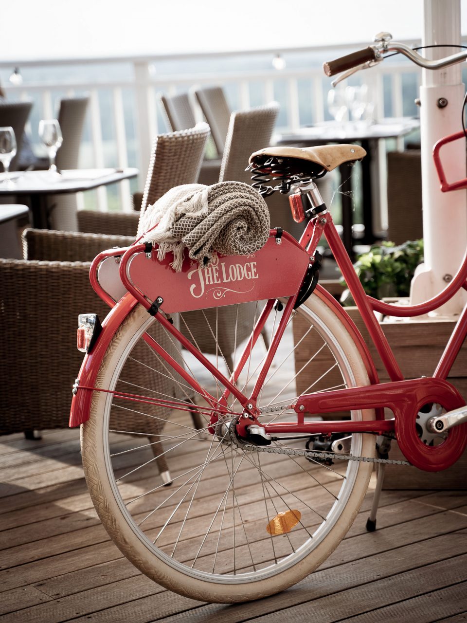 Röd cykel med filt i korgen utanför The Lodge på Romeleåsen