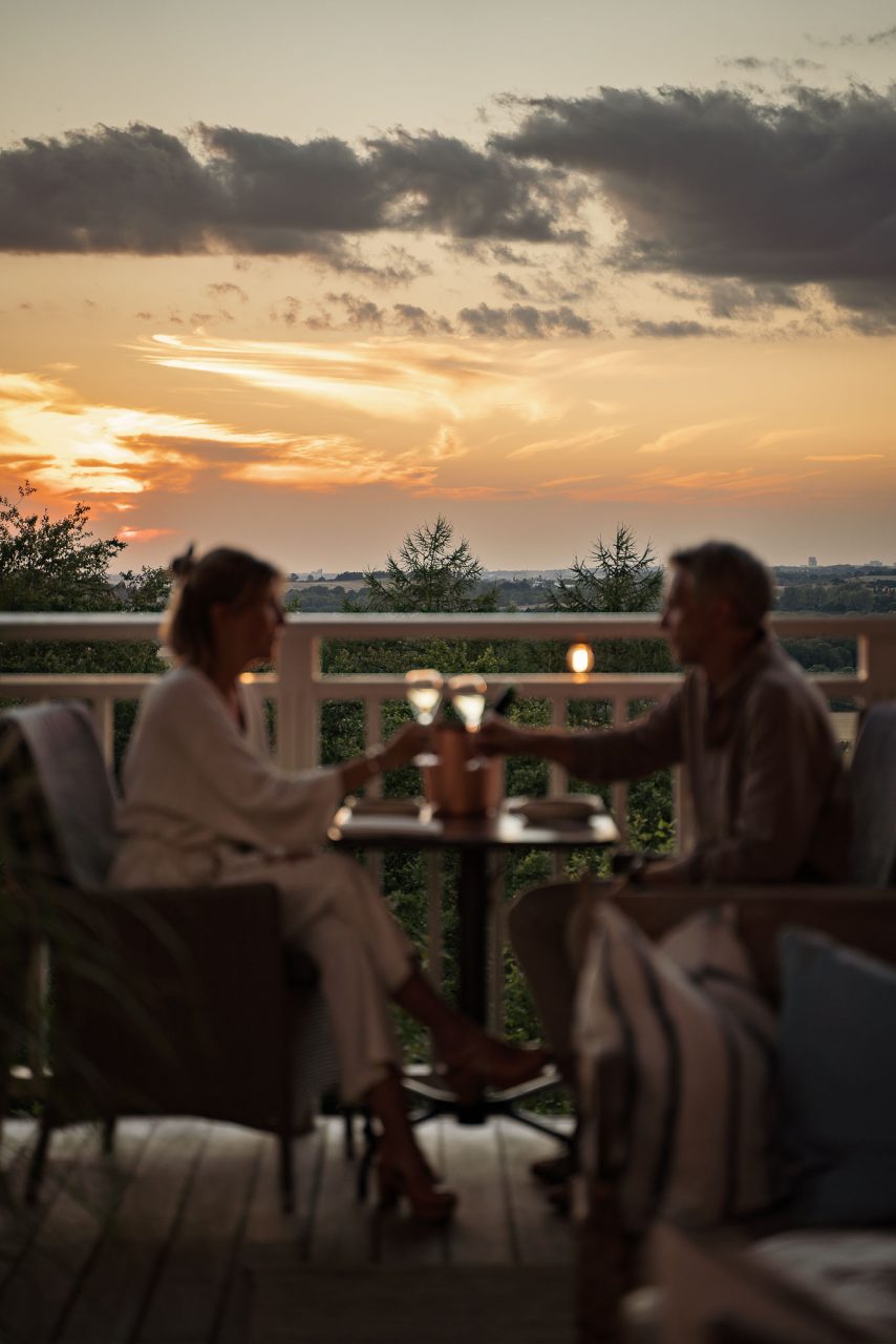 Par med drink på verandan i solnedgång på The Lodge