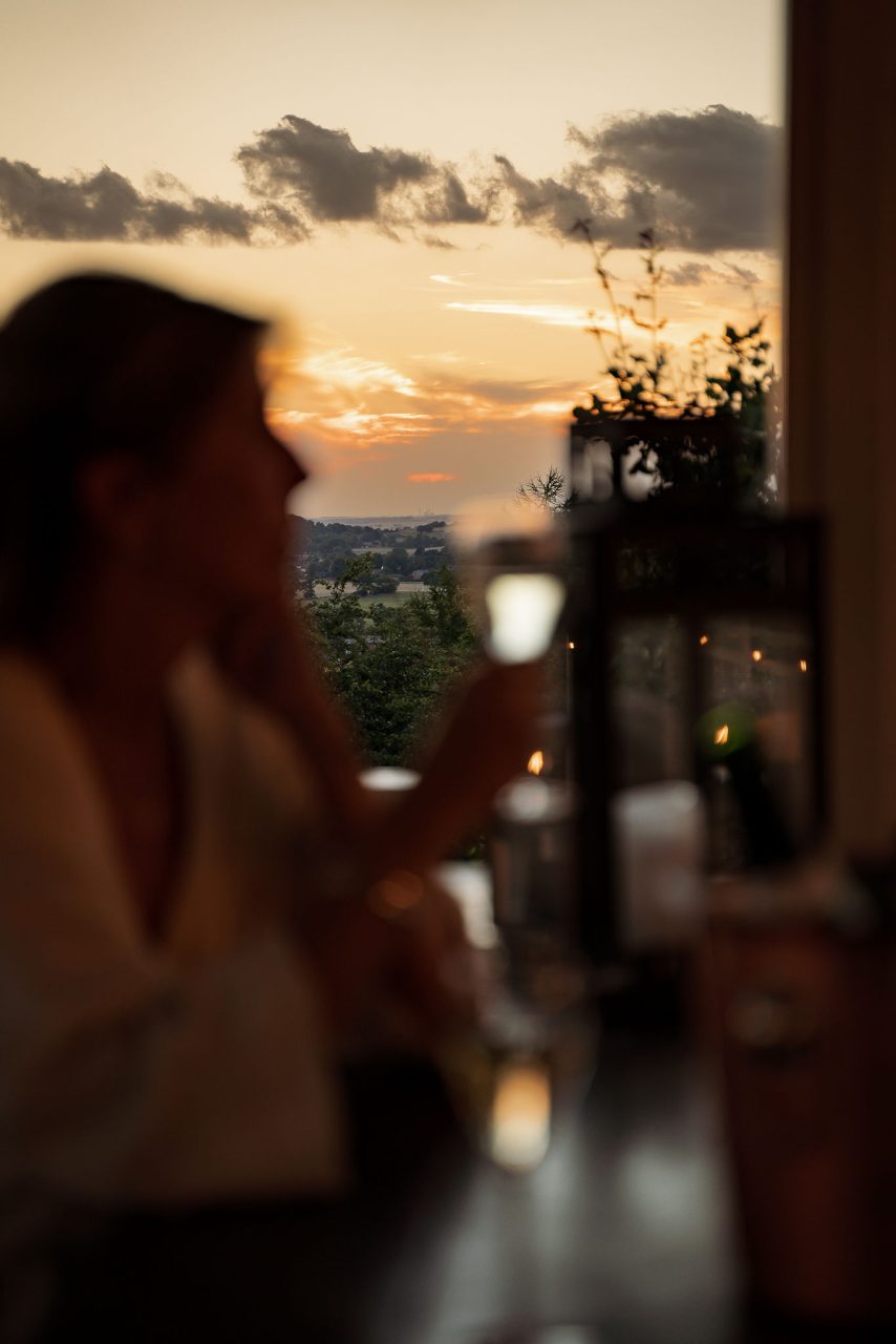 Gäst med glas i solnedgången på The Lodge