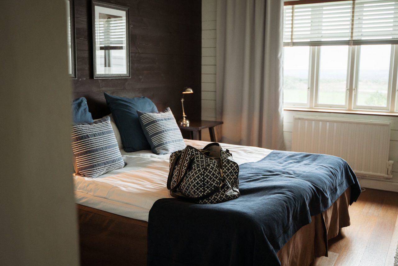 Hotellrum med väska på sängen på The Lodge i Skåne